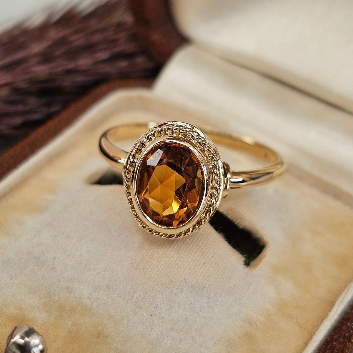 Bague ancienne en or 18 carats sertie d'une citrine ovale entourée d'un motif tressé, travail français