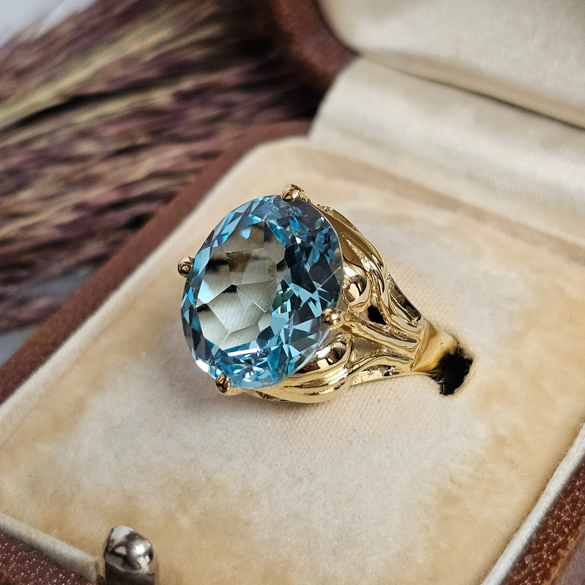 Bague cocktail vintage en or jaune sertie d'une importante topaze ovale dans un décor végétal