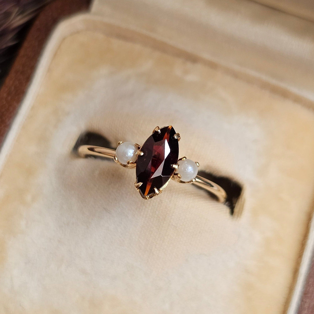 Bague fine ancienne en or rose, de style trilogie, sertie d'un grenat forme marquise et de deux perles