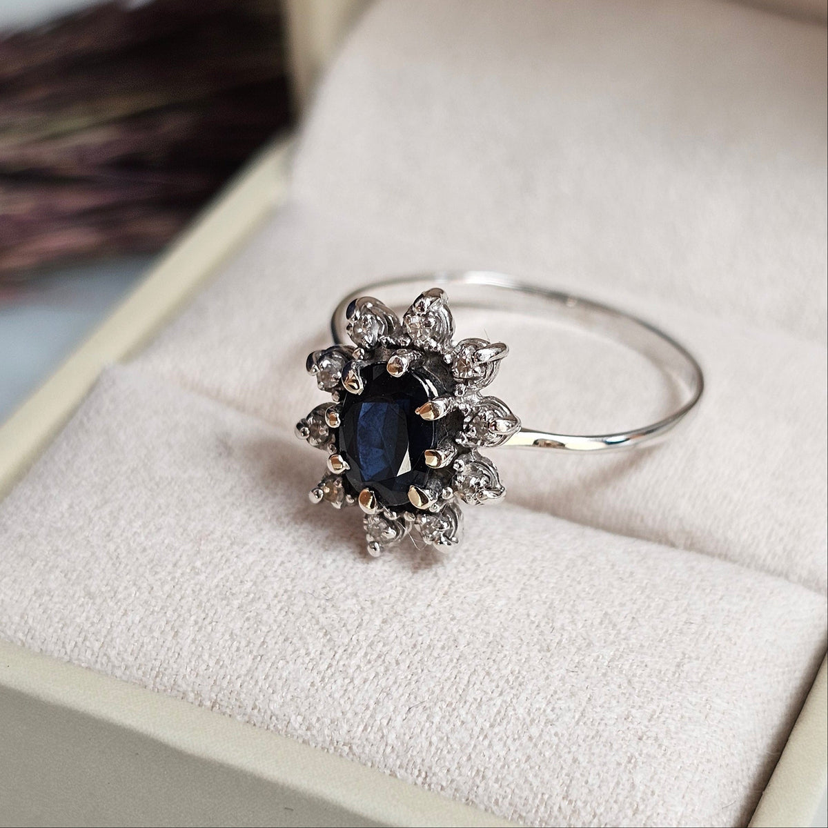 Bague vintage de forme marguerite en or blanc sertie d'un saphir et de diamants, vue gros plan de profil