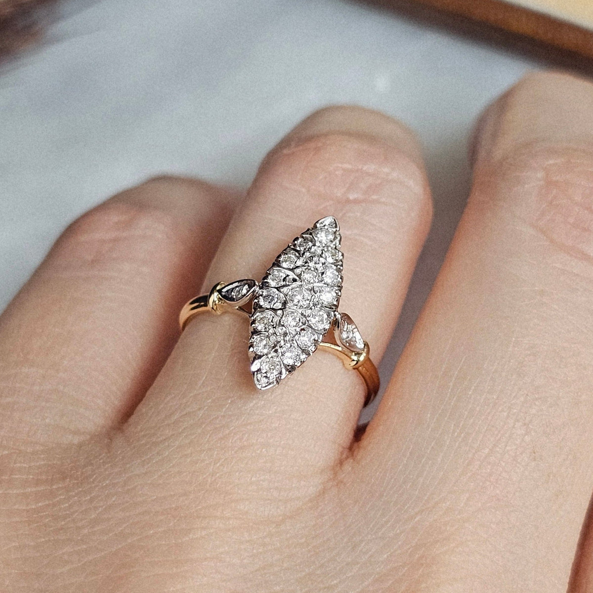 Bague vintage de forme marquise avec plateau en or blanc et anneau en or jaune, sertie de diamants.