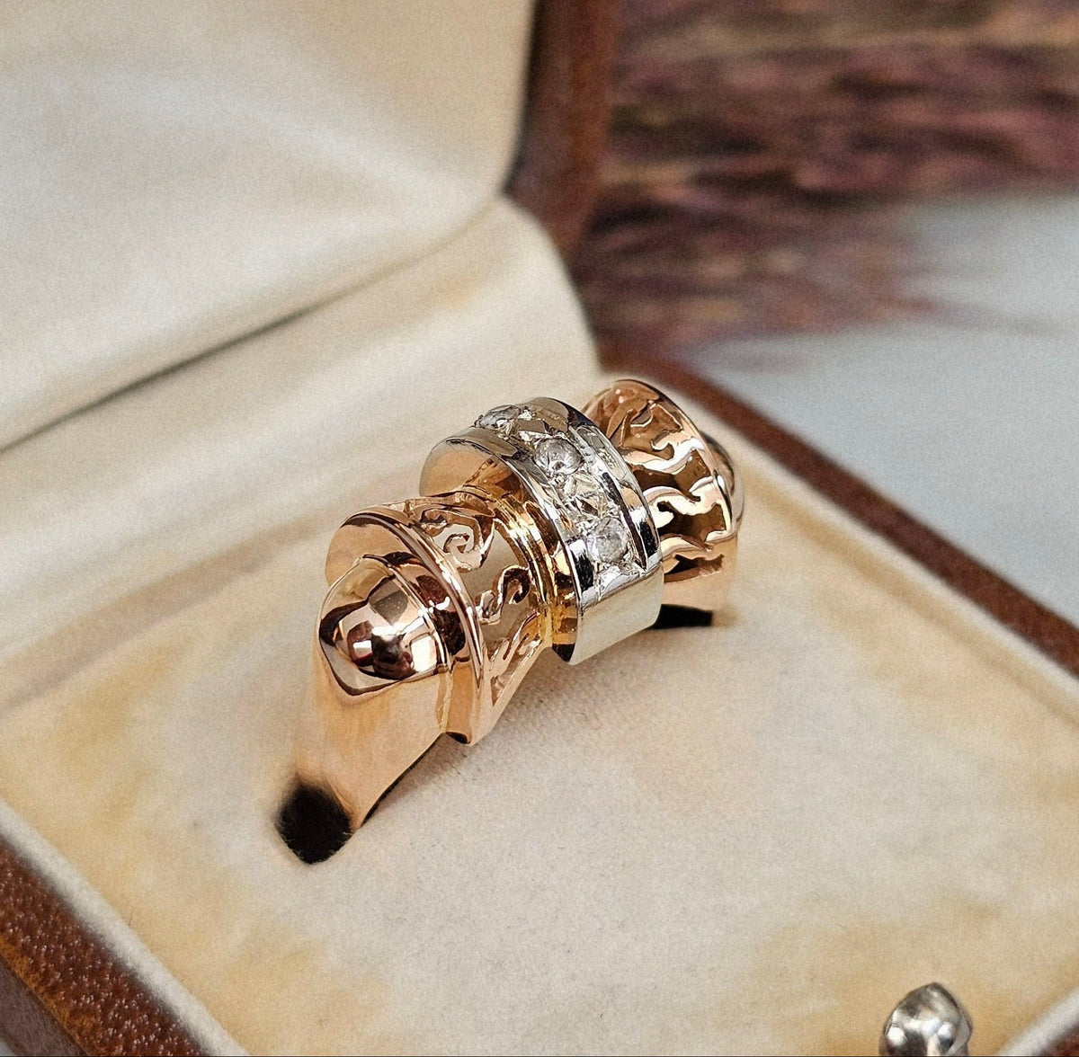 Bague ancienne vers 1940 en forme de noeud stylisé, en or rose et blanc, sertie de trois pierres blanches