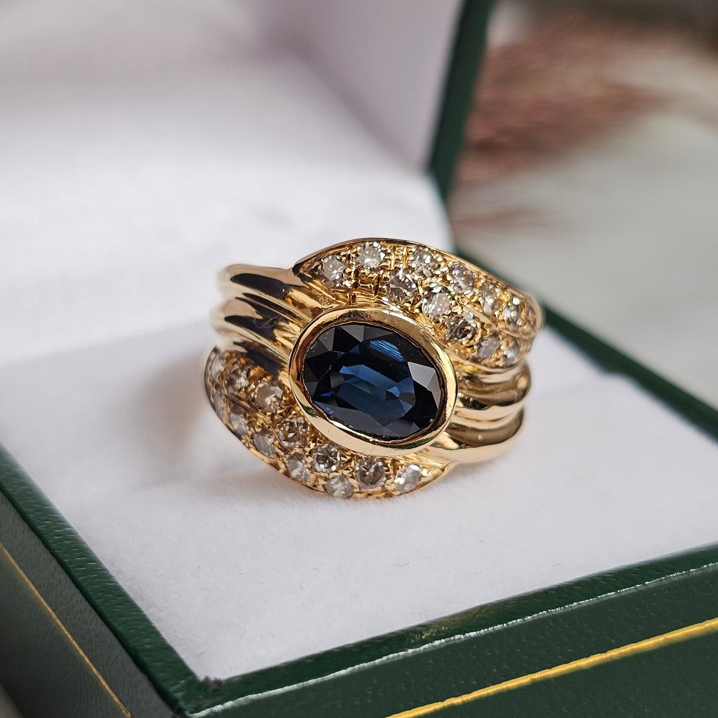 Bague vintage, type cocktail, vers 1980 en or jaune 18 carats, sertie d'un saphir et de diamants.