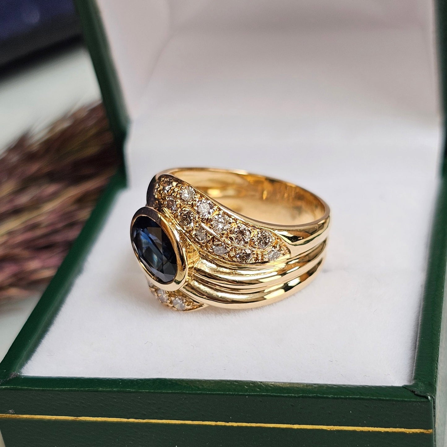 Bague vintage, type cocktail, vers 1980 en or jaune 18 carats, sertie d'un saphir et de diamants, vue de côté.