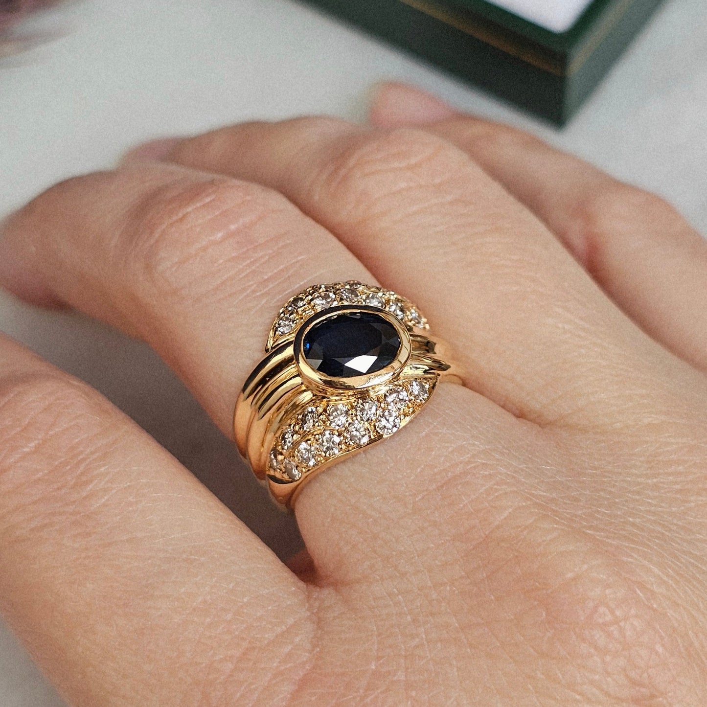 Bague vintage, type cocktail, vers 1980 en or jaune 18 carats, sertie d'un saphir et de diamants, autre vue portée.