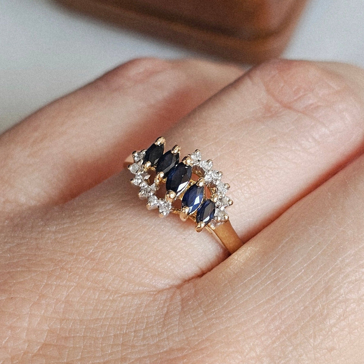 Bague vintage style rivière, sertie d'une ligne centrale de saphirs taille navette, encadré de deux lignes de diamants sur une monture en or jaune 18 carats, vers 1990.