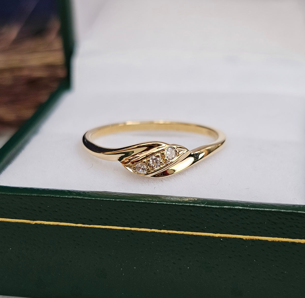 Bague vintage fine en or jaune, de style trilogie, sertie de trois pierres blanches, gros plan