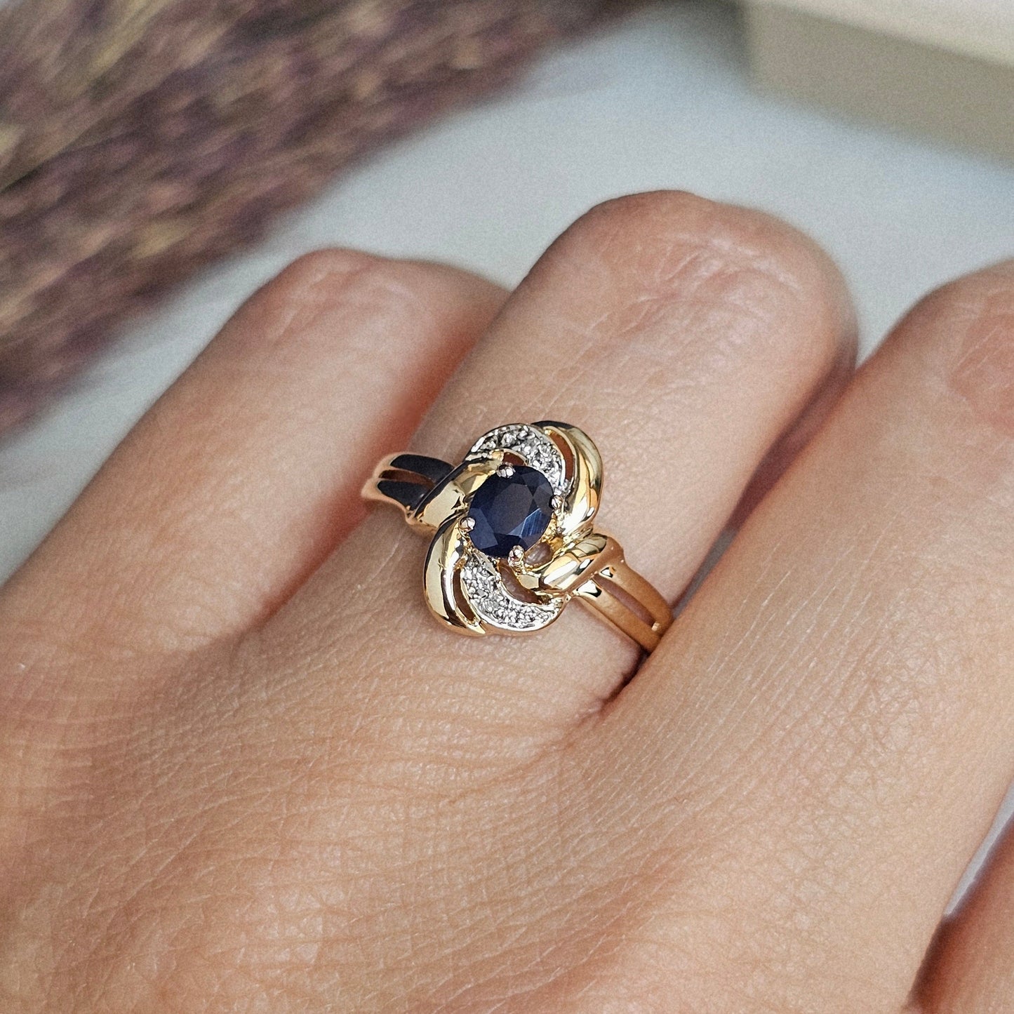 Bague vintage en or jaune 18 carats avec saphir et diamants, portée.