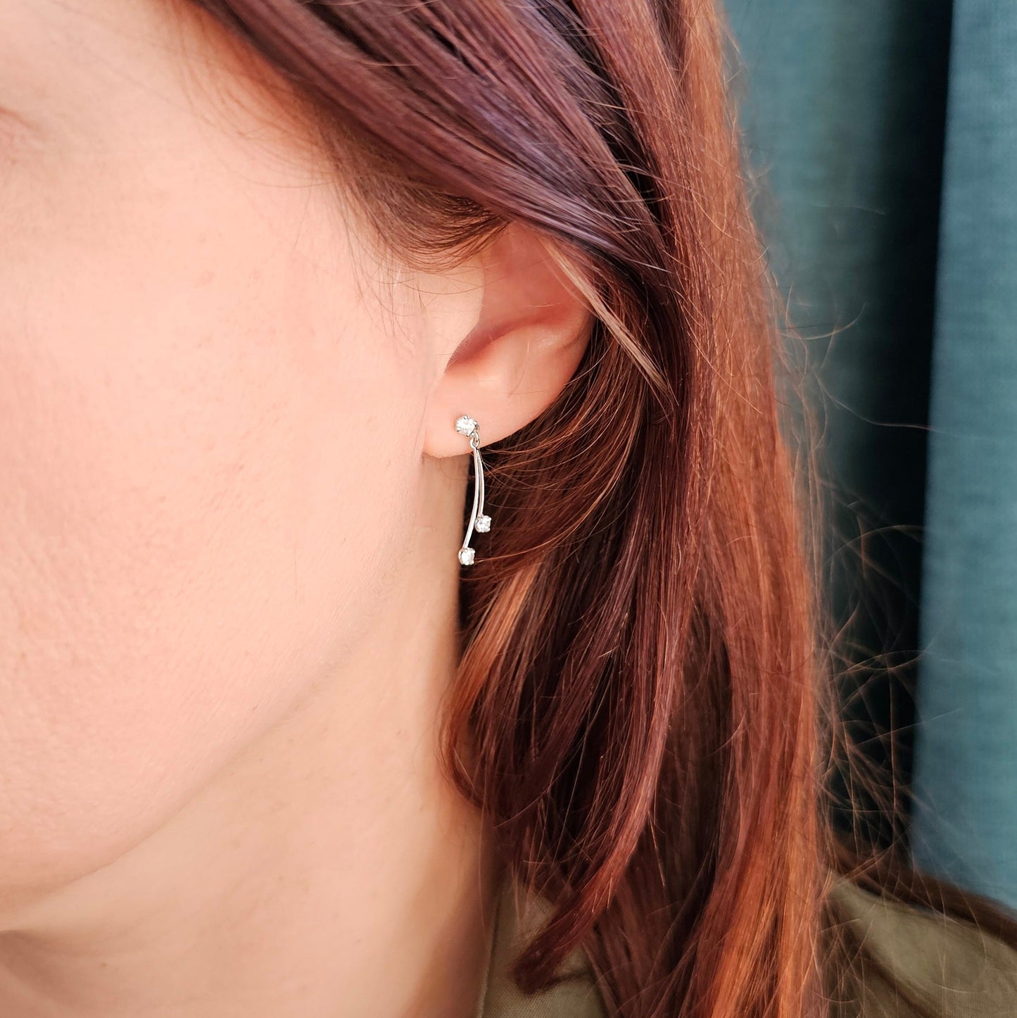 Boucles d'oreilles vintage fines en or blanc 18 carats serties de pierres blanches imitant le diamant, vue portée.