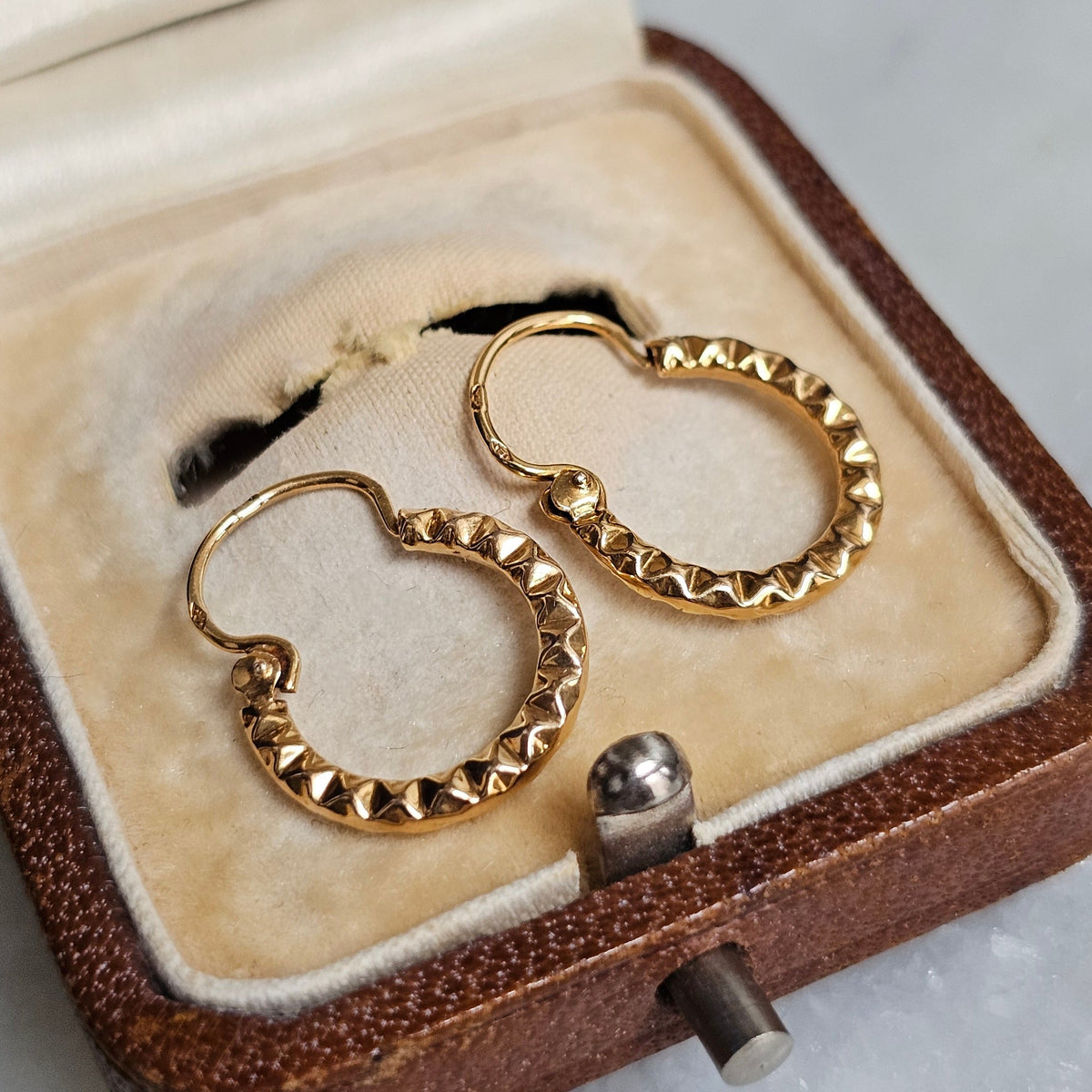 Boucles d'oreilles créoles anciennes en or 18 carats à motif dentelé, vue du dessus