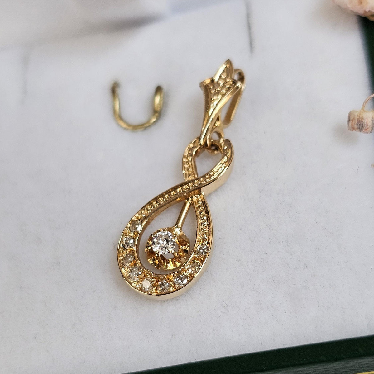 Pendentif vintage de forme entrelacée rappelant le signe infini, en diamants et or 18 carats, de profil