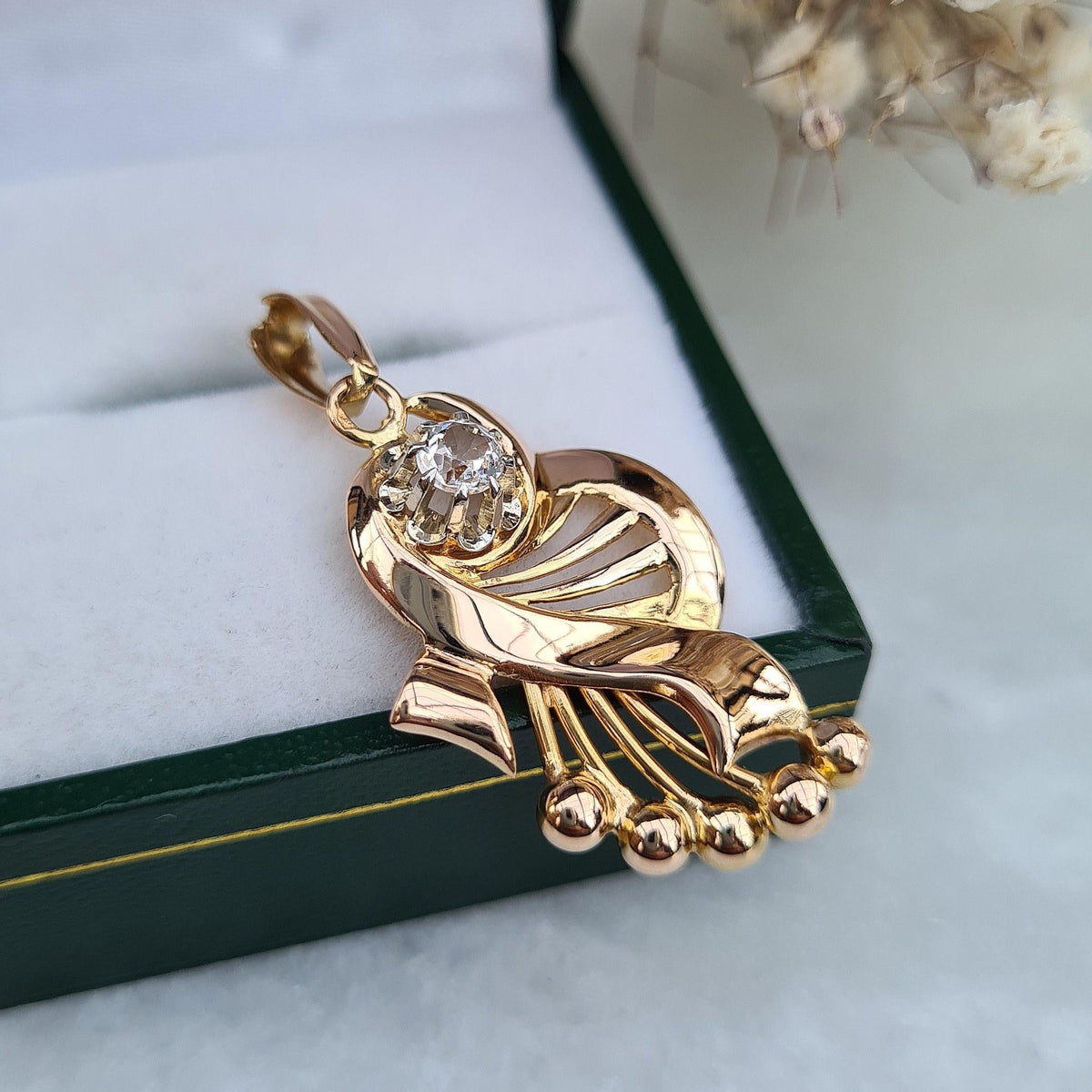 Pendentif vintage de forme entrelacée, rappelant l'univers musical, en or 18 carats et pierre blanche imitant le diamant, vue de profil
