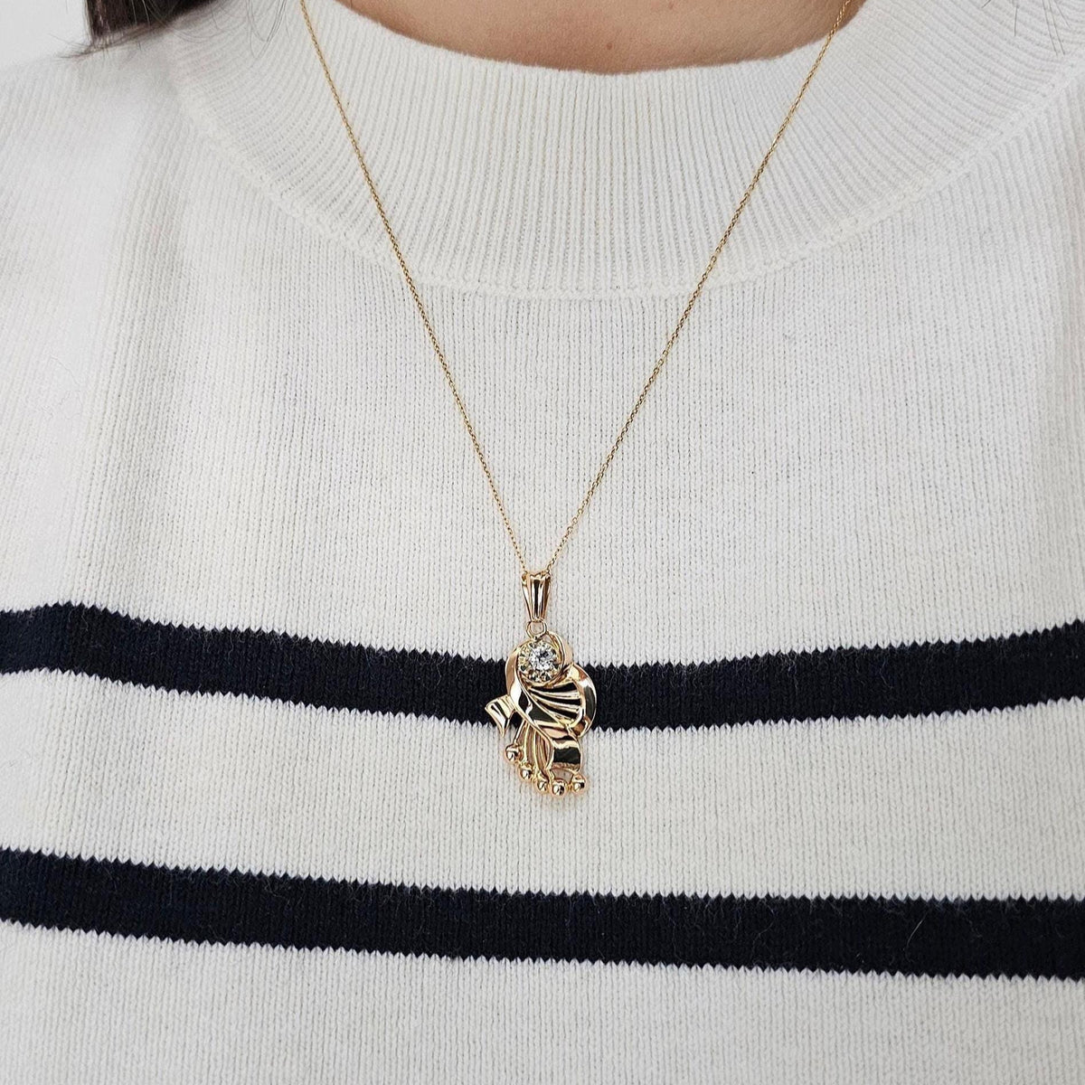 Pendentif vintage de forme entrelacée, rappelant l'univers musical, en or 18 carats et pierre blanche imitant le diamant, vue portée