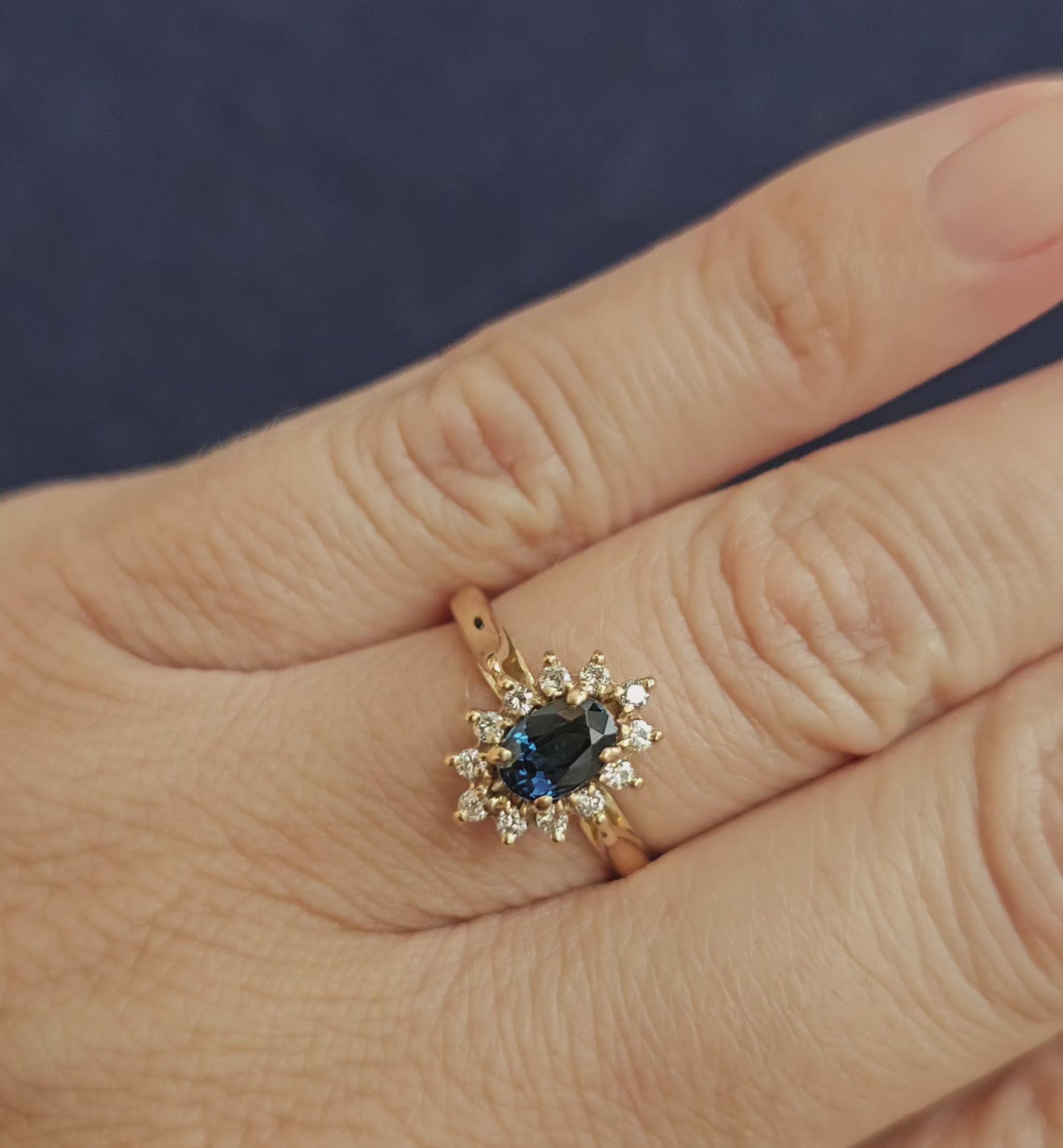 Bague de fiançailles type marguerite, avec saphir et diamants, sur une monture en or jaune 18 carats, vidéo